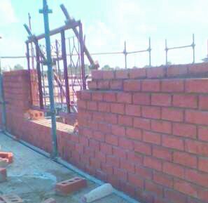 Brick wall under construction with scaffolding
