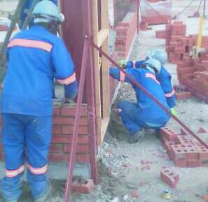 Crew laying blockwork in blue overalls